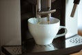 Close up of coffee machine pouring cappuccino, espresso, americano in white cup Royalty Free Stock Photo