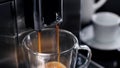 Close up of coffee pouring from coffee machine in a cup Royalty Free Stock Photo