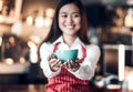 Close up on coffee up with blur asian woman barista holding mug