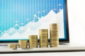 Close up coin stacked growing on financial graph chart in laptop Royalty Free Stock Photo