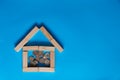 Close-Up Of Coins With Model Home On Wooden Table Against Blue Background Royalty Free Stock Photo