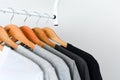 Collection of black, gray and white color hanging on wooden clothes hanger in closet or clothing rack Royalty Free Stock Photo