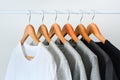 Collection of black, gray and white color hanging on wooden clothes hanger in closet or clothing rack Royalty Free Stock Photo