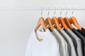 Collection of black, gray and white color hanging on wooden clothes hanger in closet or clothing rack Royalty Free Stock Photo