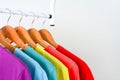 Collection of colorful rainbow t-shirts hanging on wooden clothes hanger on clothing rack over white background Royalty Free Stock Photo