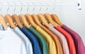 Close up collection of colorful t-shirts hanging on wooden clothes hanger in closet or clothing rack over white background, copy Royalty Free Stock Photo