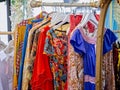 Close up of collection of colourful vintage dresses on sale at market stall at Frome Sunday Market, Somerset, UK