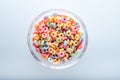 Close up of colored fruit cereal loops in bowl .on a blue background.top view Royalty Free Stock Photo