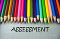 Close up colored pencil writing with ASSESSMENT .Education concept