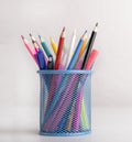 Close up of colored pencils in blue transparent stand on white Royalty Free Stock Photo