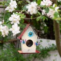 Close-up of a colorful birdhouse on a blurred floral background Royalty Free Stock Photo