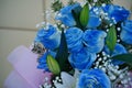 Close up of colorful bouquet of flowers. Flower composition of blue roses and white lilies in wrapping paper Royalty Free Stock Photo