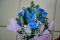 Close up of colorful bouquet of flowers. Flower composition of blue roses and white lilies in wrapping paper Royalty Free Stock Photo
