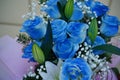 Close up of colorful bouquet of flowers. Flower composition of blue roses and white lilies in wrapping paper Royalty Free Stock Photo