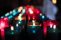 Close up of colorful candles in a dark spiritual scene. Commemoration, funeral, memorial. Religious symbolism