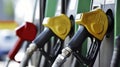 a close-up of colorful fuel pumps at a gas station, with red and yellow nozzles against a blurred background Royalty Free Stock Photo