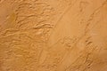 Close-up of colorful golden bronze plastered uneven stucco wall. Abstract texture, chaotic copy space background. Decorative Royalty Free Stock Photo