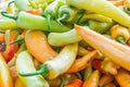 Close up of colorful green, yellow and orange jalapeno peppers, being sold at a farmer`s market Royalty Free Stock Photo