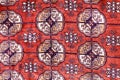 Close-up of colorful handmade silk carpet with pattern in red tones, traditional uzbekistan style.