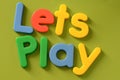 Close up of colorful Lets Play words on green back Royalty Free Stock Photo