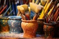 close-up of colorful pottery glazes and brushes