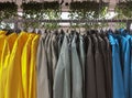 Close-up colorful raincoats on hanging racks in clothing fashion store. Casual clothing