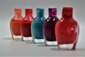 Close up colorful set of old nail polish bottles on a white surface. No top on the bottles