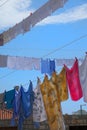 CLOSE UP: Colorful sheets, clothes, and towels are hung to dry in summer air. Royalty Free Stock Photo