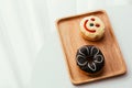 Close up of colorful and sweet donuts and one smiley face donut near windows.