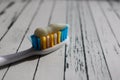 Close up of colorful toothbrush with toothpaste close up macro on wooden table Royalty Free Stock Photo