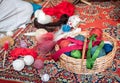 Close up colorful yarn in basket red, rose, blue, green, coiled in ball skein on wolen carpet. Knitting and crochet