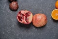 Close up of colourful pomegranate with orange on a dark grey stone background Royalty Free Stock Photo