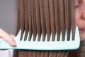 Close up combing healthy and natural shiny hair, isolated on studio. Beauty hair care.