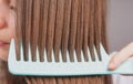 Close up combing healthy and natural shiny hair, on studio. Beauty hair care.