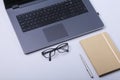 Close-up of comfortable working place in office with laptop, notebook, glasses, pen and other equipment laying on table Royalty Free Stock Photo