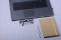 Close-up of comfortable working place in office with laptop, notebook, glasses, pen and other equipment laying on table Royalty Free Stock Photo