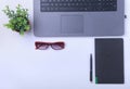 Close-up of comfortable working place in office with laptop, notebook, glasses, pen and other equipment laying on table Royalty Free Stock Photo