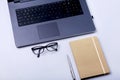 Close-up of comfortable working place in office with laptop, notebook, glasses, pen and other equipment laying on table Royalty Free Stock Photo