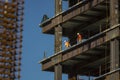 Close up of commercial office building under construction with construction workers ,steel beams,land rebar.