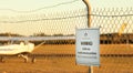 Warning sign at regional airport. Security fence and infrastructure at airfield