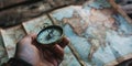 A close-up of a compass held in a traveler's hand, with a map and rustic wooden table Royalty Free Stock Photo