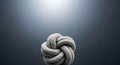 Close-up of a complex, textured rope knot against a dark, gradient background with spotlight Royalty Free Stock Photo