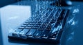 A close-up of a computer keyboard with a digital overlay. Binary code streams ver Royalty Free Stock Photo