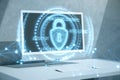 Close up of computer monitor on desk with glowing polygonal padlock hologram on blurry background. Secure, safety and technology Royalty Free Stock Photo