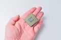 Close-up of a computer processor chip held in a person's hand against a white background Royalty Free Stock Photo