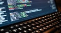 Close-up of computer screen displaying code with illuminated keyboard detailed view Royalty Free Stock Photo