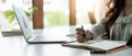 Close up of concentrated female student busy studying using laptop make notes in notebook, focused man worker employee Royalty Free Stock Photo