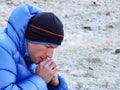 Close up of a concentrated and pensive mountain climber in thick down jacket lost in thought Royalty Free Stock Photo