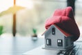 Close up conceptual of insulation symbol house with red bonnet in office bureau. insurance protective hand over house for Royalty Free Stock Photo