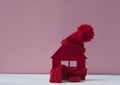 Close up conceptual miniature model house with red wool scarf hat on wooden background Royalty Free Stock Photo